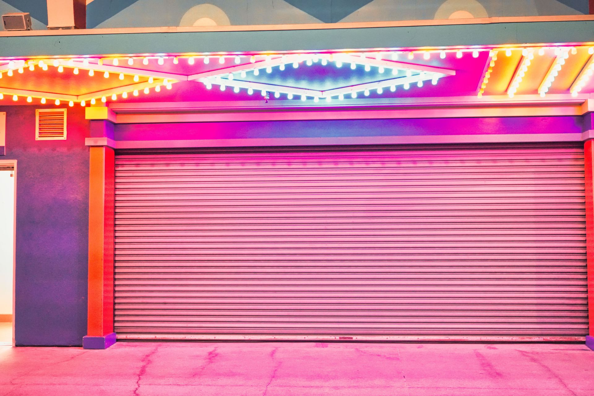 A brightly colored garage door illuminated by vivid neon lights in a retro style setting.